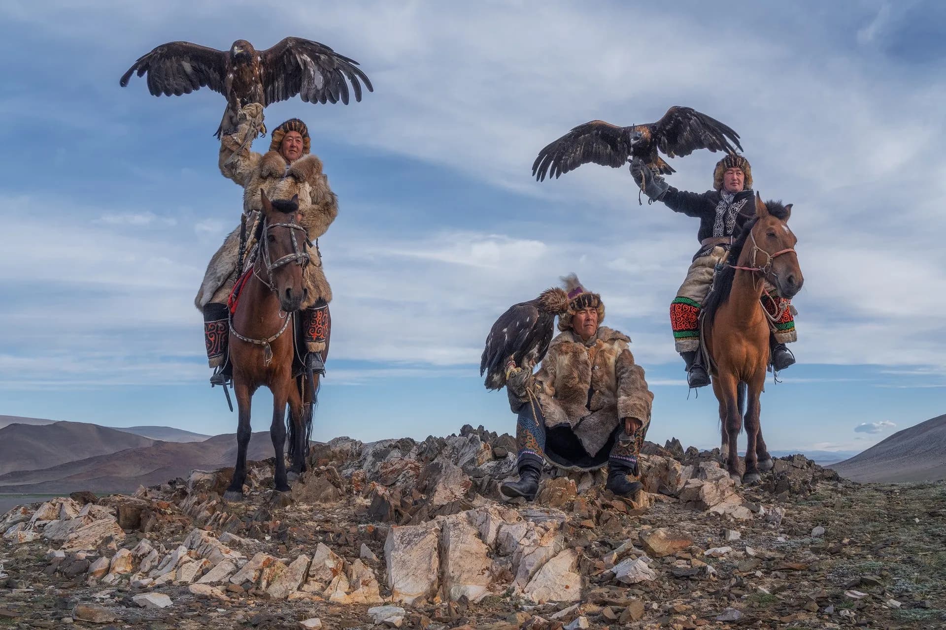 Kazakh eagle hunters against the mountain landscape of Bayan-Ölgii